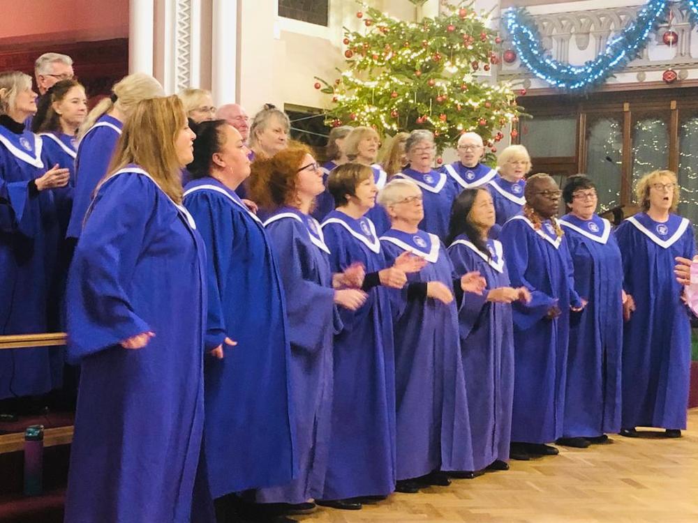 The Liverpool Harmonic Gospel choir all dressed in blue choir robes.