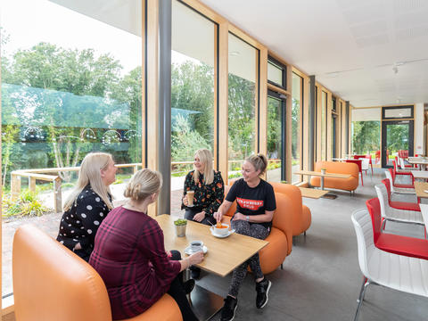 People sit at table by windows in Strawberry Field cafe